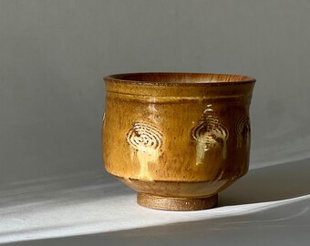 Textured creamy wheel thrown stoneware ceramic tea cup.