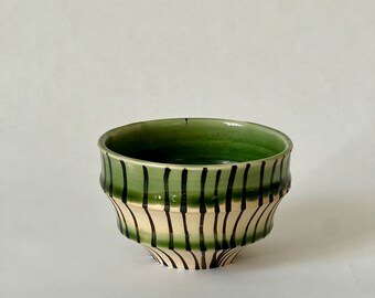 Green and black hand painted wheel thrown stoneware ceramic tea cup.
