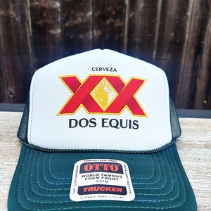 May include: A white and green trucker hat with a red and yellow "Dos Equis" logo. The hat has a mesh back and a foam front.