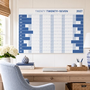 May include: A large horizontal wall calendar for the year 2027, titled TWENTY TWENTY-SEVEN. The white calendar features a grid layout with months listed on the left in blue, and days of the month arranged in columns with alternating blue and white vertical stripes.