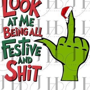 May include: A green hand giving the middle finger, wearing a Santa hat, with the text "LOOK AT ME BEING ALL FESTIVE AND SHIT" in red and green. The design is on a white background.