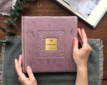 May include: A purple velvet photo album with a gold embossed design and the text "Family Album" on the front.