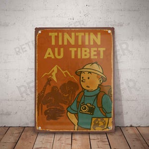 May include: A vintage-style metal sign featuring a cartoon illustration of Tintin, with the text "TINTIN AU TIBET" in yellow. The sign has a brown background with a mountain and animal silhouettes.
