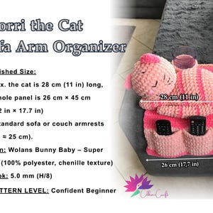 May include: A handmade, pink and red crochet sofa arm organizer shaped like a cat, with two pockets for remotes and a space for a glass. The cat is 11 inches long, and the panel is 10.2 x 17.7 inches. The text "Snorri the Cat Sofa Arm Organizer" is visible.