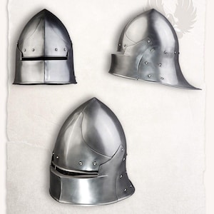 Op de afbeelding: Drie middeleeuwse stalen helmen worden getoond tegen een getextureerde witte achtergrond. De helmen hebben een gepolijste, metalen afwerking en zijn voorzien van geklonken constructie. Elke helm heeft een ander ontwerp, met variaties in middeleeuwse bepantsering.