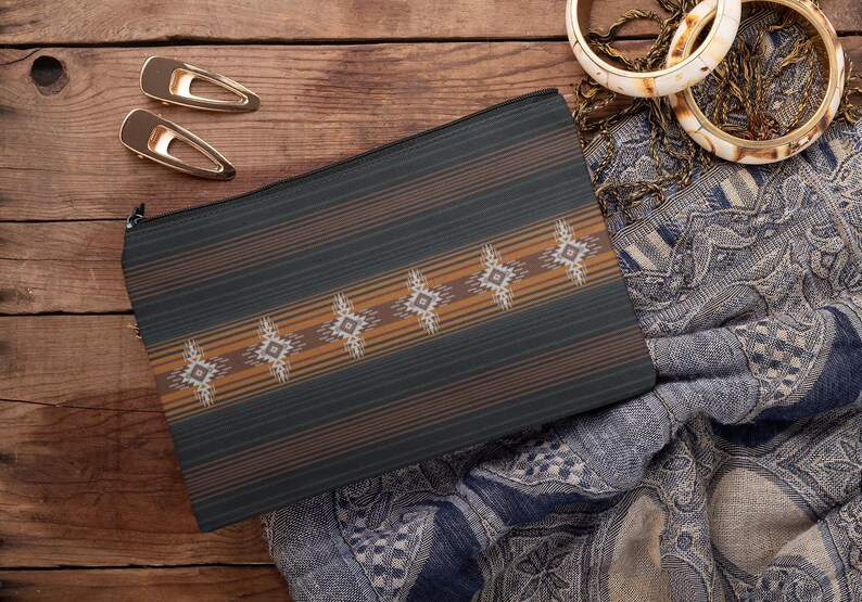 May include: A dark green and brown patterned zippered pouch with a geometric design. Two gold hair clips and two ivory and gold bangles are also visible. The pouch is on a wooden surface.