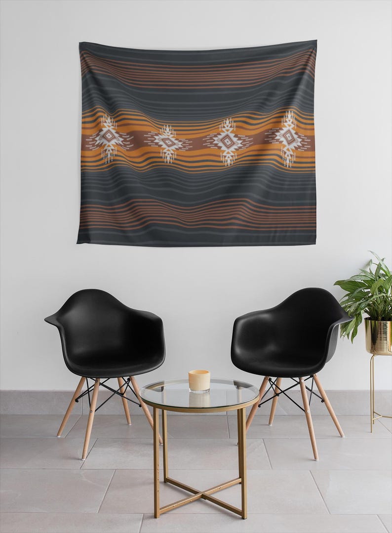 May include: A dark gray tapestry with horizontal orange and brown stripes and four geometric designs. The tapestry is hanging on a white wall above two black chairs and a small glass table.