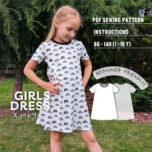 Peut inclure: Une robe à manches courtes avec un motif arc-en-ciel noir et blanc et un col rond. Le texte indique : PDF SEWING PATTERN, INSTRUCTIONS, 86-140 (1-10 Y), GIRLS DRESS Gaby, BEGINNER FRIENDLY, avec un croquis technique de la robe.