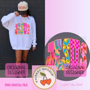 Puede incluir: Sudadera blanca con un gr&aacute;fico colorido de "JESUS". El dise&ntilde;o incorpora caras sonrientes, patrones de tablero de ajedrez y remolinos psicod&eacute;licos. Se usa una gorra beige con "I LOVE YOU". La imagen tambi&eacute;n incluye un logotipo de "Whiskey Shoals" con cerezas.