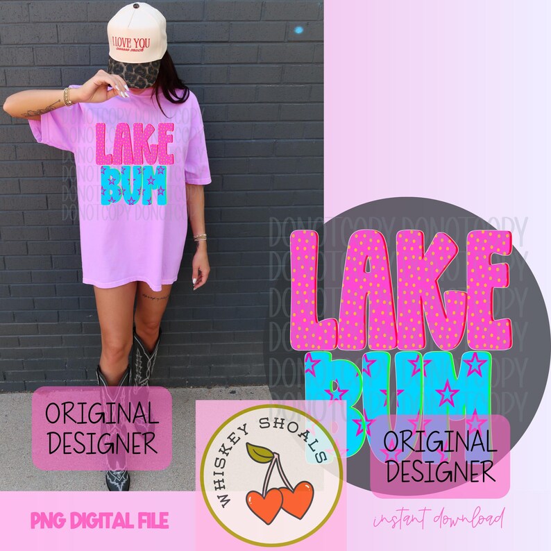 Puede incluir: Una camiseta de color lila claro con las palabras "LAKE BUM" en rosa y azul, con un dise&ntilde;o de lunares y estrellas. La imagen tambi&eacute;n incluye un logotipo de "Whiskey Shoals" con cerezas y el texto "ORIGINAL DESIGNER".