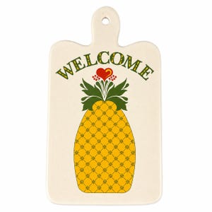 May include: A rectangular off-white ceramic serving board with a handle and a hole for hanging. The center features a yellow pineapple graphic with a green leafy top, a small red heart, and the word WELCOME printed in green above the pineapple.