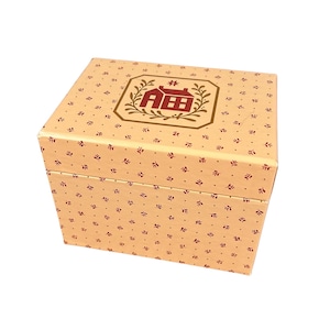 May include: A square, beige box with a repeating pattern of small red leaves and dots. The box lid features a framed design with a red house graphic and the letters "ABB". The box is likely for storage or gifting.