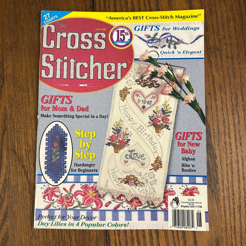 May include: A copy of "Cross Stitcher" magazine with a pink and red cover. The cover features text and images related to cross-stitch projects, including gifts for various occasions. The magazine also includes step-by-step instructions for beginners.