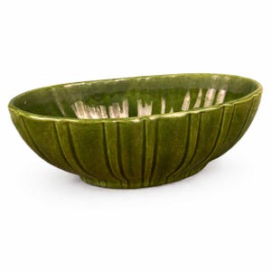 May include: A green ceramic oval bowl with vertical ribbed detailing. The bowl has a glossy finish and a slightly irregular shape. The interior has a lighter, almost white, color. This decorative bowl is suitable for serving or display.