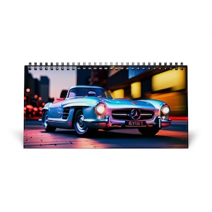 May include: A calendar showing a light blue classic car with a red interior, parked on a city street. The car has the license plate "E161". The background features blurred city lights and buildings.