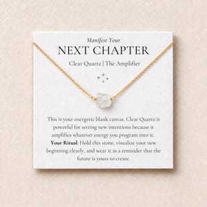 May include: A gold-tone chain necklace featuring a raw, clear quartz pendant, displayed on a white card printed with the text: Manifest Your NEXT CHAPTER, Clear Quartz | The Amplifier, and instructions for setting intentions and rituals.