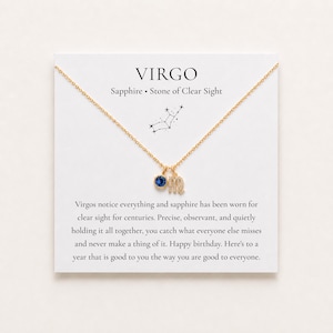 Può includere: Una collana color oro con un ciondolo circolare in zaffiro blu e un ciondolo con il simbolo zodiacale della Vergine. La collana è esposta su un cartoncino bianco stampato con il testo VIRGO, Sapphire Stone of Clear Sight e un diagramma costellazione.