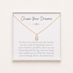 May include: A gold-tone chain necklace with an oval opal pendant centered on a white display card. The card features the text Chase Your Dreams and an inspirational message about opal being a stone of infinite possibility and capability.