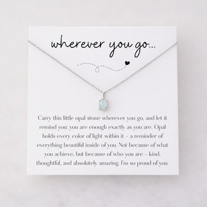 Puede incluir: Un collar de plata con un peque&ntilde;o colgante de &oacute;palo azul claro. El colgante cuelga de una delicada cadena. La tarjeta detr&aacute;s del collar tiene las palabras "wherever you go..." y un mensaje sobre la autoestima.