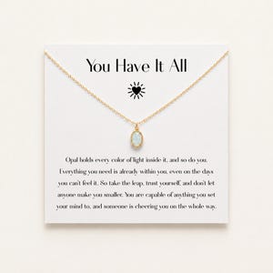 May include: A gold chain necklace with an oval opal pendant displayed on a white card featuring the text You Have It All, a sun icon, and a paragraph about opal light. The necklace is centered on the card, which provides a message of encouragement.