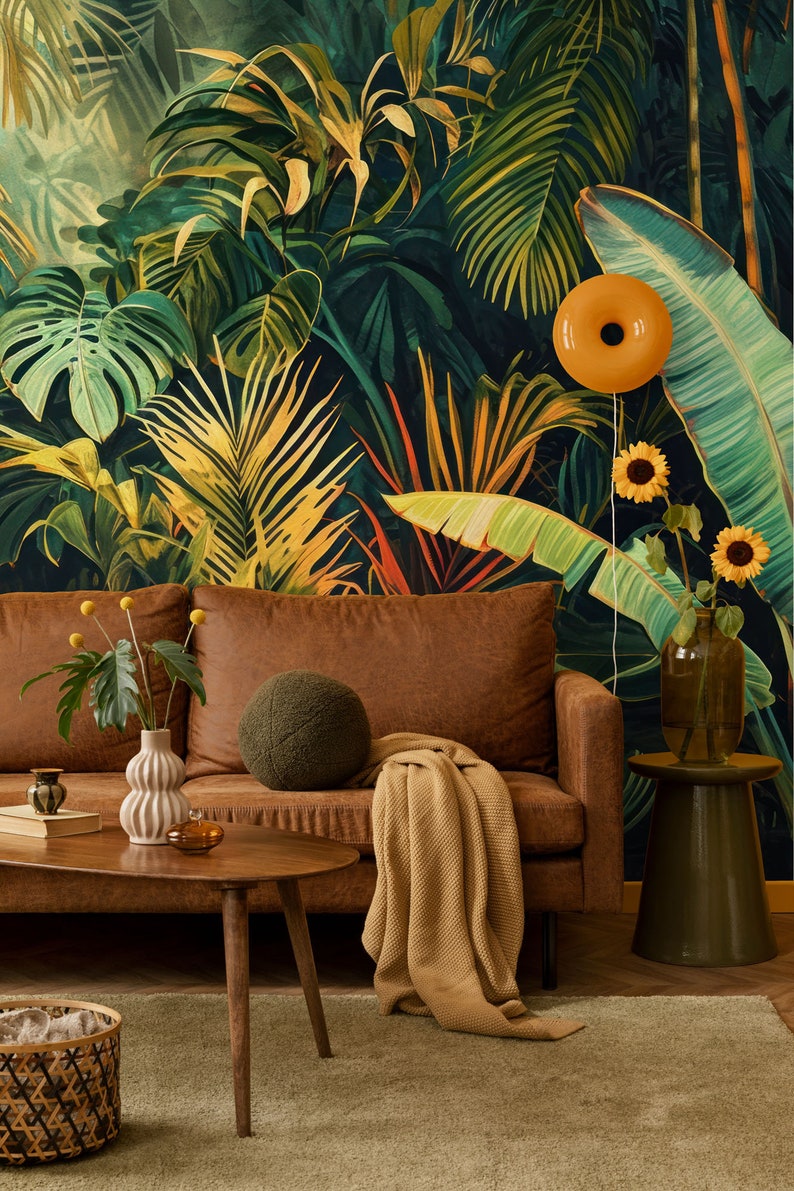 Peut inclure: Un canap&eacute; en cuir marron avec un coussin de jet vert et une couverture en jet beige. Le canap&eacute; est devant un mur avec un papier peint &agrave; motif tropical repr&eacute;sentant de grandes feuilles vertes et des fleurs jaunes. Une table basse en bois avec un vase de fleurs jaunes se trouve devant le canap&eacute;.