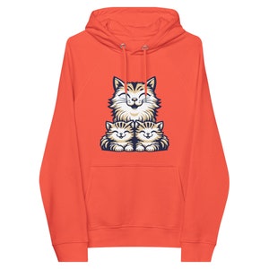 Könnte beinhalten: Orangefarbener Hoodie mit einem Motiv einer Mutterkatze und zwei Kätzchen. Die Katzenfamilie lächelt und kuschelt sich aneinander.
