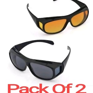 Puede incluir: Dos pares de gafas de sol negras con diseño envolvente. Un par tiene lentes ámbar y el otro par tiene lentes grises. El texto "Pack Of 2" está impreso debajo de las gafas de sol.