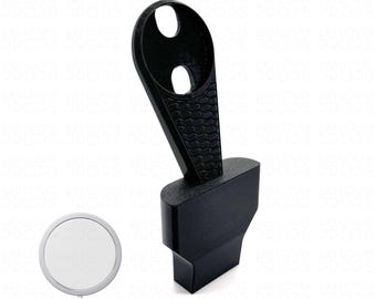 May include: A black charging stand with a unique design. The stand features a textured, angled arm with two circular openings at the top. The base is rectangular. The text "Charger Not Included" is at the bottom.