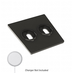 Op de afbeelding: Een zwart oplaadstation met twee ovale uitsparingen, elk met het label "MagSafe 20W". Een witte ronde oplader wordt eronder getoond. De tekst onderaan luidt "Oplader niet inbegrepen".