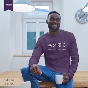 Może przedstawiać: Fioletowy longsleeve z białym nadrukiem ikon przedstawiających sen, jedzenie, kodowanie i powtarzanie. Tekst pod ikonami brzmi "sleep(); eat(); code(); repeat();".