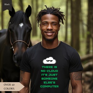Puede incluir: Una camiseta negra con un gráfico de nube blanca con gafas de sol y el texto "THERE IS NO CLOUD IT'S JUST SOMEONE ELSE'S COMPUTER" en verde.