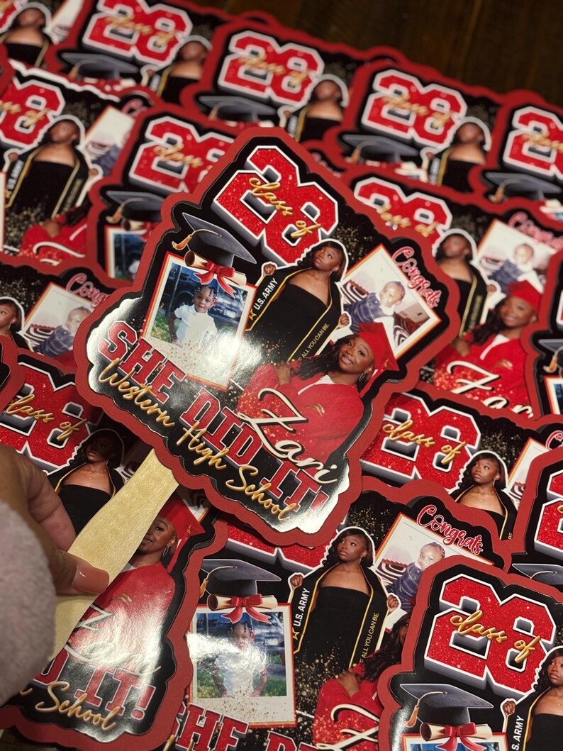 May include: A collection of red and black graduation stickers. Each sticker features a photo of a graduate, the text "Class of 23", and the words "She Did It!" and "Western High School".