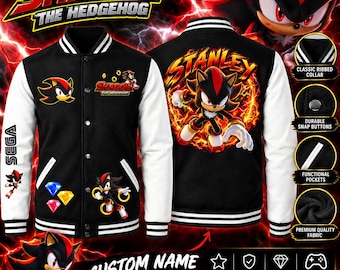Puede incluir: Una chaqueta universitaria negra y blanca con gráficos de Shadow the Hedgehog. El frente muestra el logo de Shadow the Hedgehog, ilustraciones del personaje y gemas coloridas. La espalda presenta un gráfico grande de Shadow con el nombre Stanley.