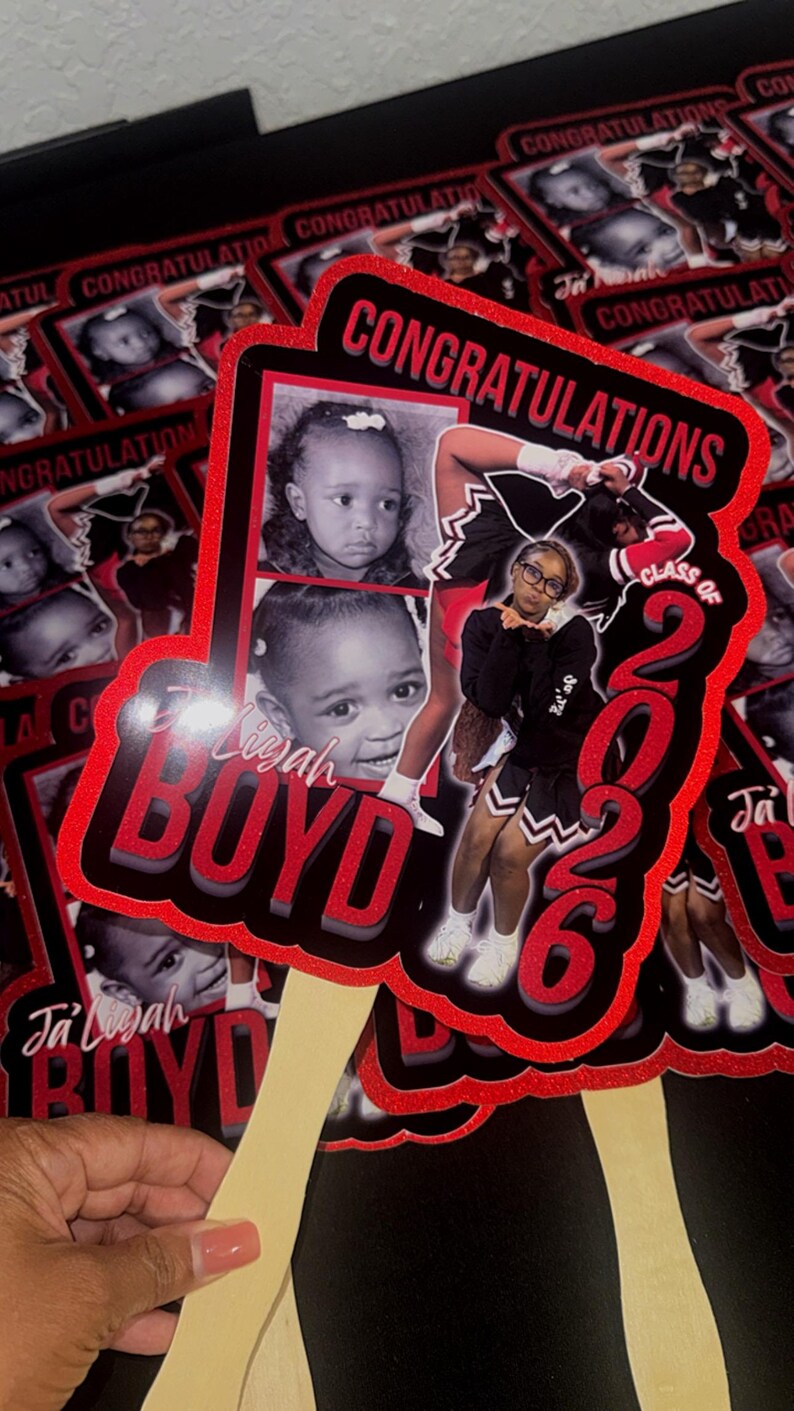 May include: A collection of graduation fan decorations. Each fan features a photo of a young person, the name "Ja'Liyah Boyd", and the text "Congratulations Class of 2026" in red and black.