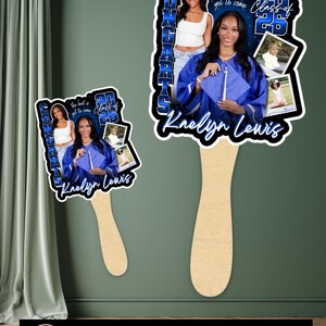 May include: Graduation fan featuring a photo of a graduate in a blue cap and gown, with the text "Congrats" and "Class of 2026". The fan has a wooden handle and includes additional photos. The text "The best is yet to come" is also visible.