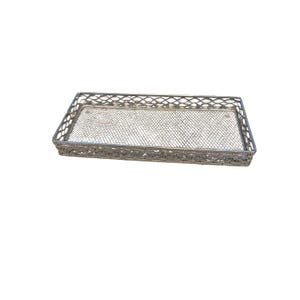 May include: A rectangular silver-toned metal tray featuring an intricate openwork lattice design on the sides and a fine wire mesh base. The tray has a structured frame with a decorative filigree pattern along the edges and a flat, stable bottom.