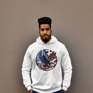 May include: White hooded sweatshirt with a graphic of an eagle flying in front of a circle with the American flag colors.
