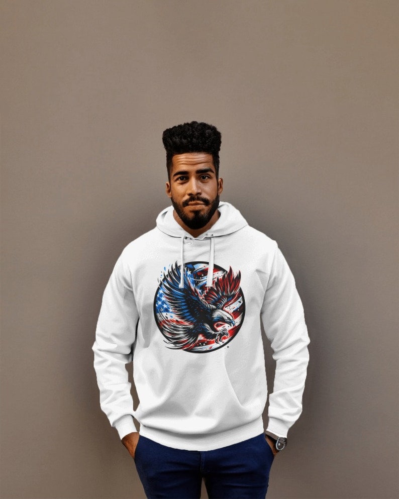 May include: White hooded sweatshirt with a graphic of an eagle flying in front of a circle with the American flag colors.