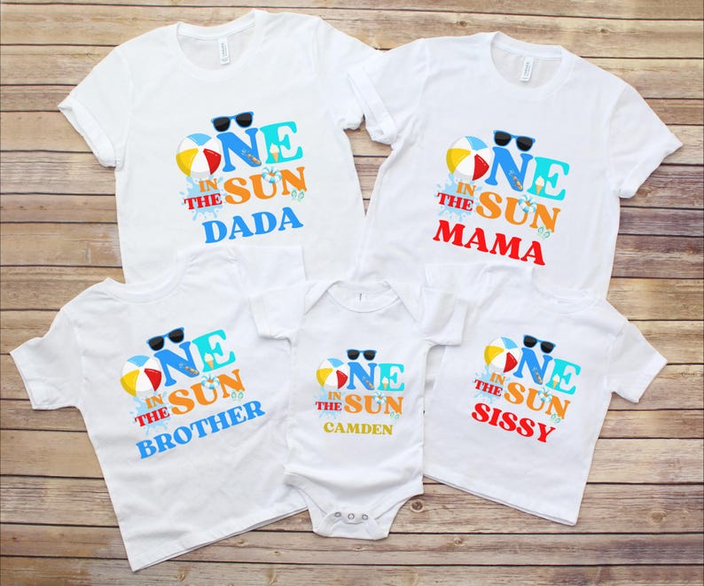 Puede incluir: Un conjunto de cinco camisetas blancas de manga corta y un body blanco de manga corta, cada uno con un estampado gr&aacute;fico que dice ONE IN THE SUN, una pelota de playa, gafas de sol y los nombres DADA, MAMA, BROTHER, CAMDEN y SISSY.