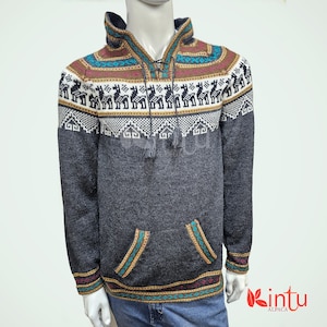 May include: A gray alpaca wool sweater with a geometric pattern and a hood. The sweater has a drawstring closure at the neck and two pockets on the front. The sweater is made in Peru by the brand "intu alpaca".