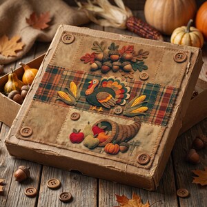 May include: A square cardboard box lid decorated with fabric appliques of acorns, a turkey, corn, and a cornucopia filled with fruit. The lid features a plaid fabric strip, brown fabric panels, and four brown buttons at the corners.