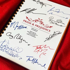 May include: A script for "PRIDE & PREJUDICE" with numerous signatures in black, blue, and red ink. The title is in red, and the script is on white paper with a spiral binding, on a red background.