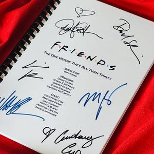Può includere: Uno script bianco con il titolo "FRIENDS" e le parole "The One Where They All Turn Thirty" scritte su di esso. Lo script ha le firme del cast dello show, tra cui Courteney Cox, Matthew Perry, Lisa Kudrow, Matt LeBlanc, Jennifer Aniston e David Schwimmer.