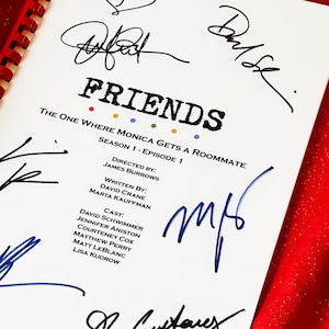 Può includere: Una sceneggiatura della serie TV "Friends", intitolata "The One Where Monica Gets a Roommate". La sceneggiatura è bianca con testo nero e punti colorati. È firmata da diverse persone con inchiostro nero e blu. La sceneggiatura è rilegata con una spirale rossa.
