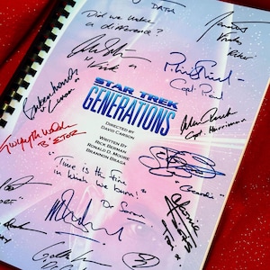 Puede incluir: Un guion encuadernado en espiral de "Star Trek Generations" con numerosas firmas en tinta azul y roja. El título se muestra de forma destacada y hay citas manuscritas.