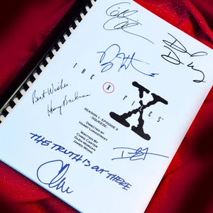 May include: A white script for the TV show "The X-Files" with the title "Squeeze" and the episode's writers and director listed. The script is signed by several people, including the show's creator Chris Carter.