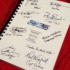 May include: A script from Star Trek: The Next Generation, Season 5, Episode 2, titled "Darmok." The white pages are filled with signatures and handwritten notes in blue ink. The Star Trek logo is visible.