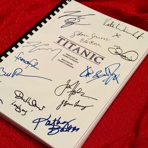 May include: A white script for the film Titanic with signatures from the cast, including Kate Winslet, Billy Zane, Kathy Bates, and others.