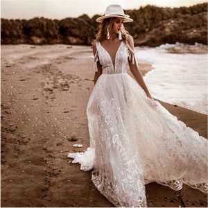 Raina | Bohemian Wedding Dress with Plunge Neckline and Off-the-Shoulder Tassels | Elegance and Bohemian Flair.