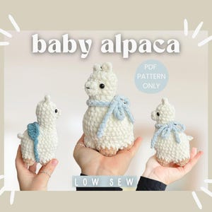 May include: Three crocheted baby alpaca toys with blue ribbon accents. The toys are white and have a fluffy texture. The text "PDF PATTERN ONLY" and "LOW SEW" are visible in the image.
